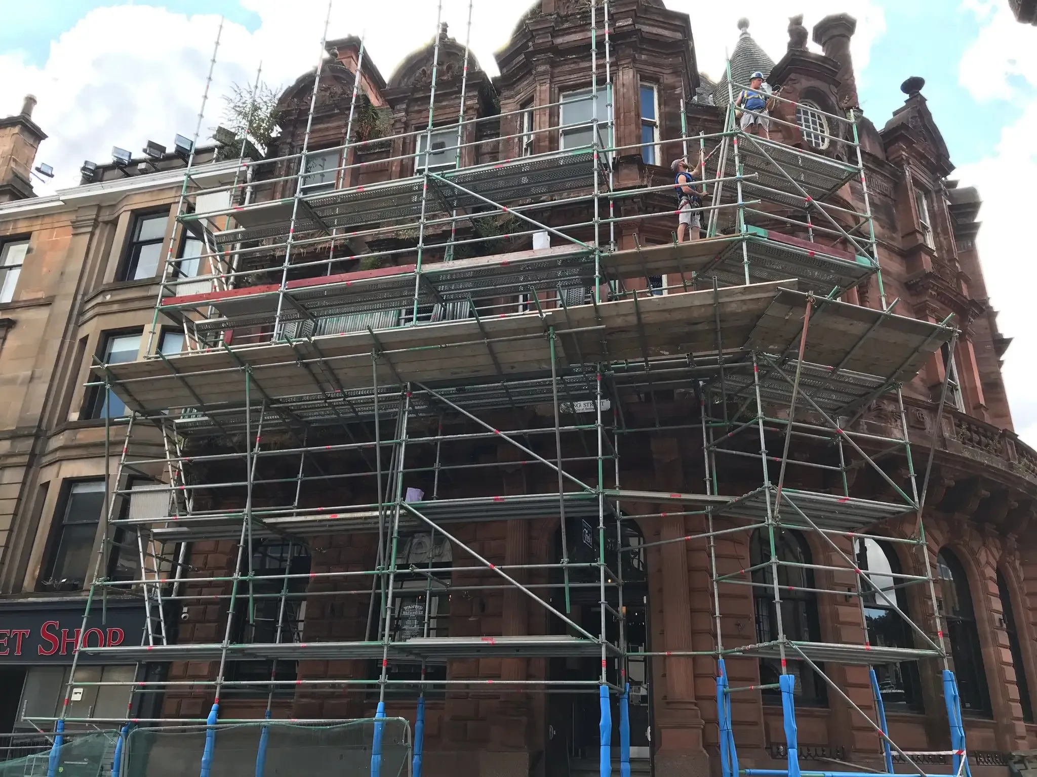 Scaffolding around two elevations of a red sandstone building