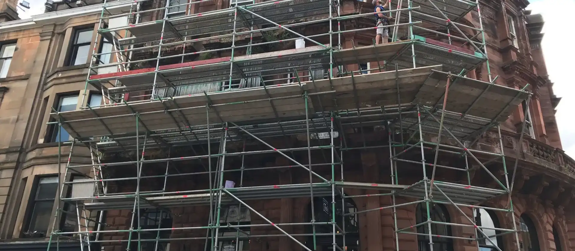 Scaffolding around two elevations of a red sandstone building