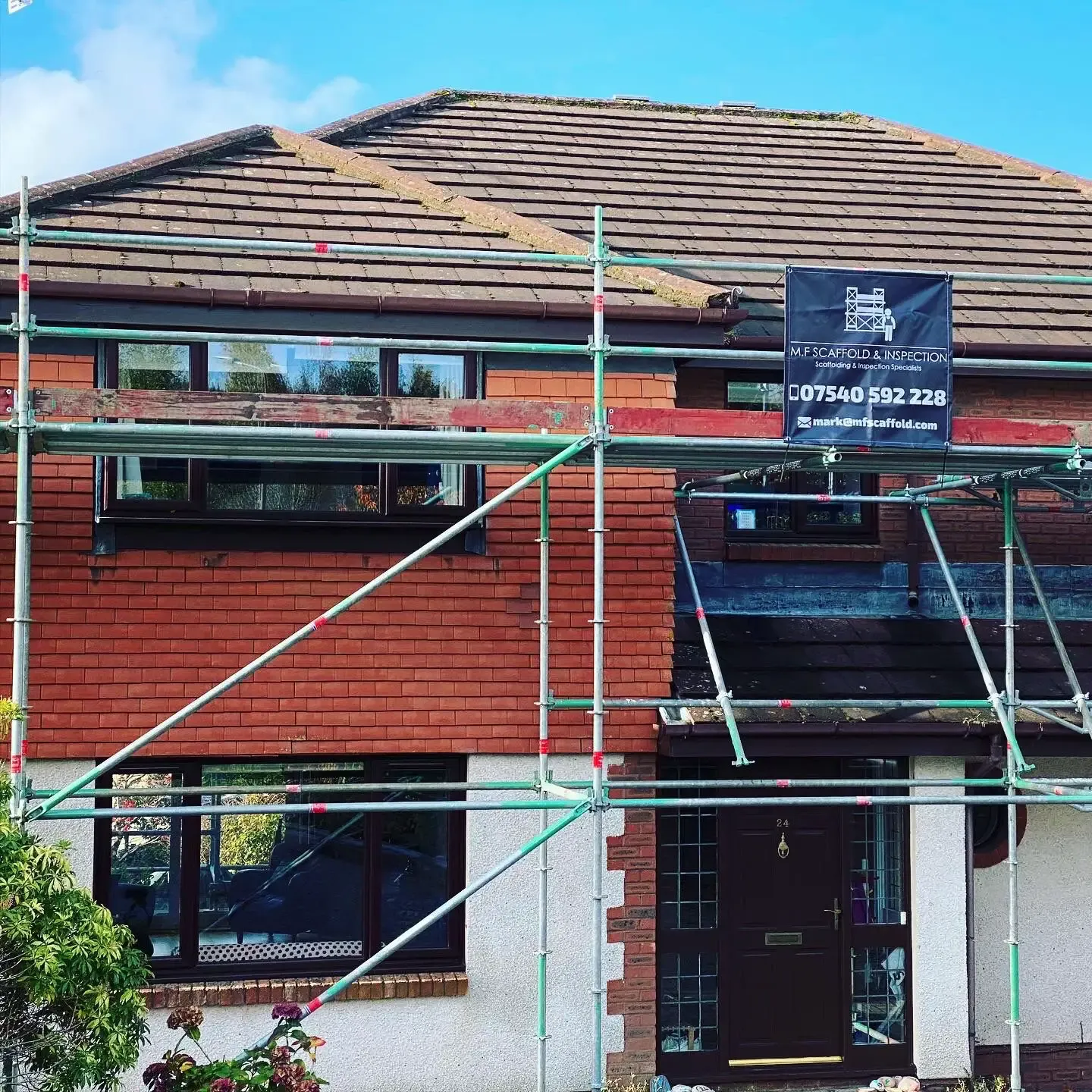 Domestic scaffolding around a house with an M.F Scaffold site banner