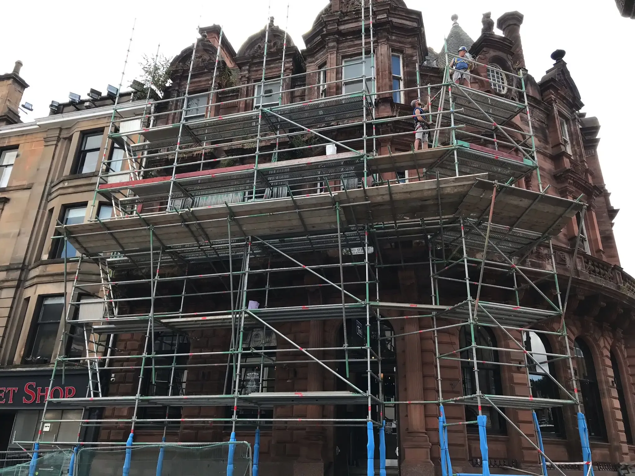 Scaffolding around the upper floors of a red sandstone building