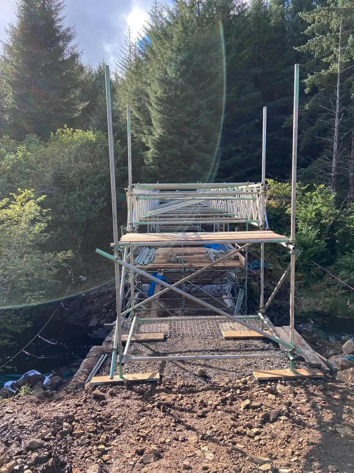 Scaffold tower built on uneven ground in woodland