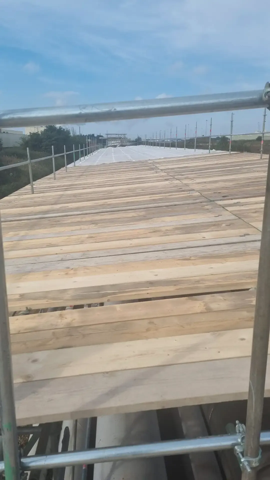 Boarded scaffold deck running the length of a long structure