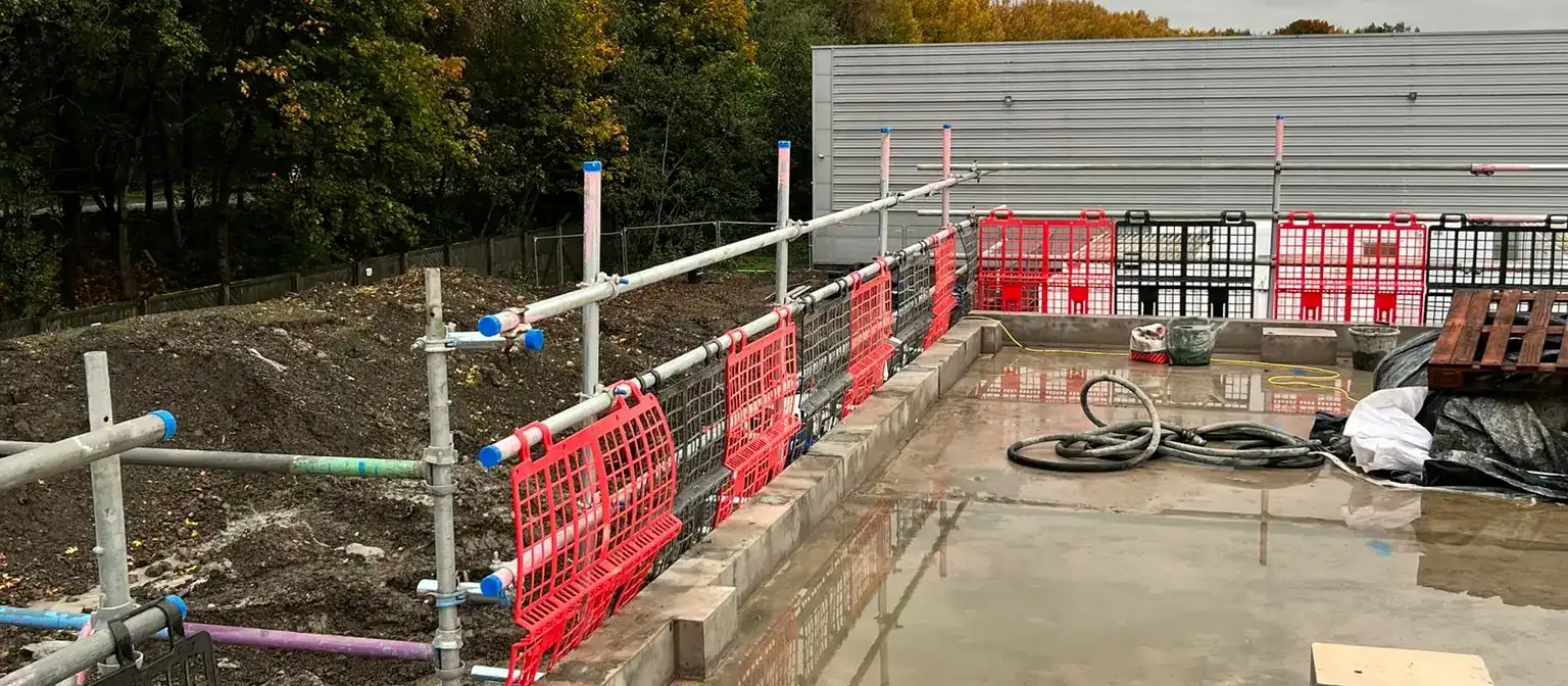 Scaffold edge protection with barrier mesh around a construction site