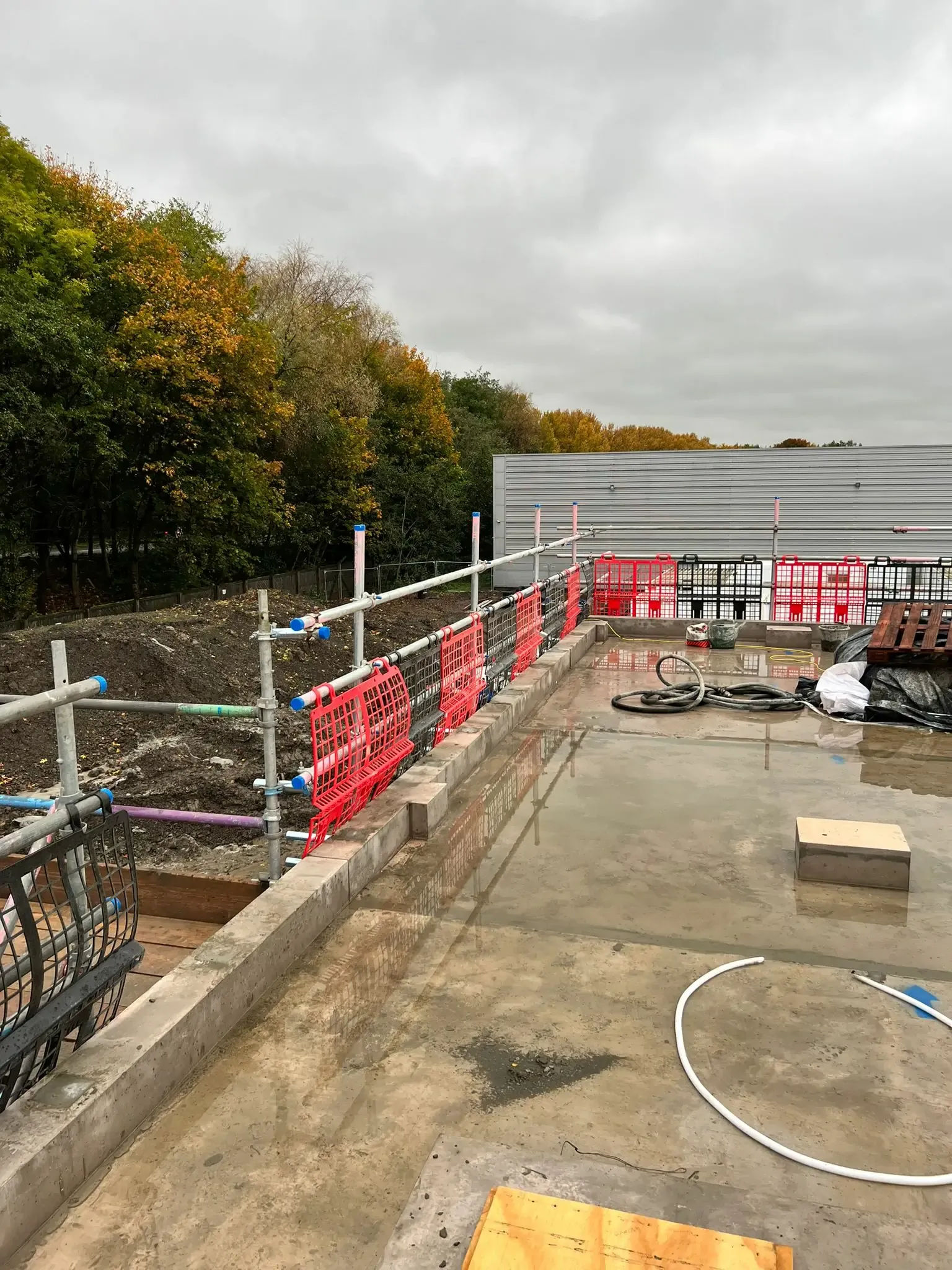 Scaffold edge protection with barrier mesh around a construction site