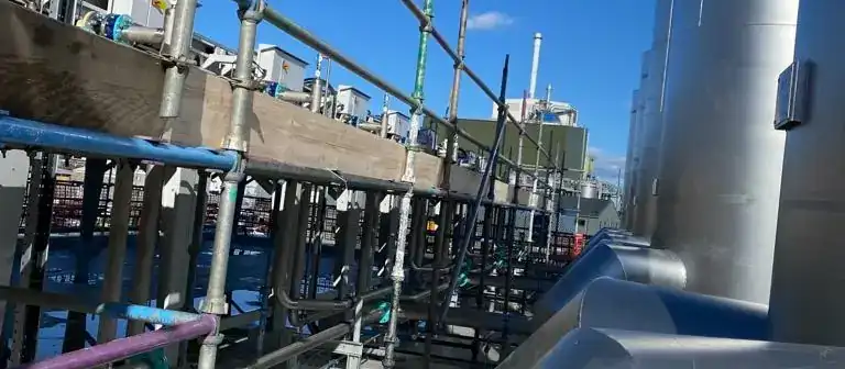 Industrial scaffolding alongside large steel pipework