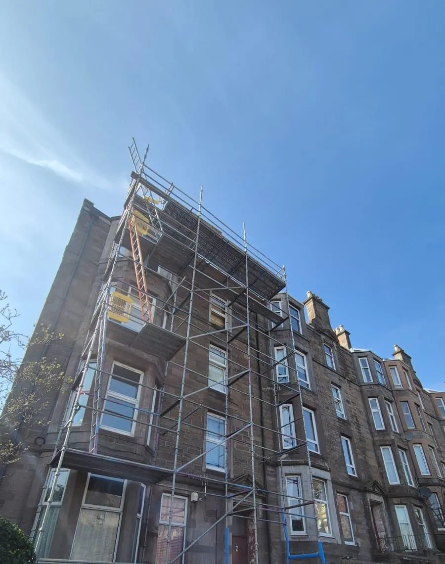 Scaffolding the full height of a sandstone tenement, up to roof level