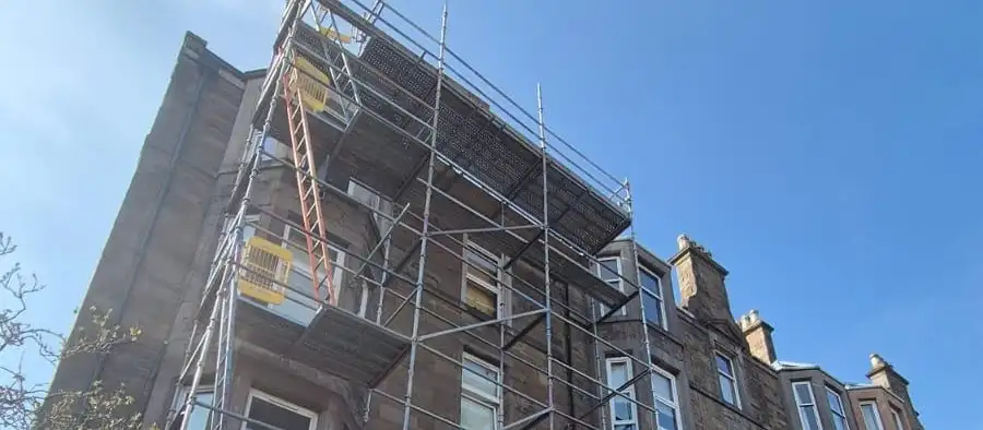 Scaffolding the full height of a sandstone tenement, up to roof level